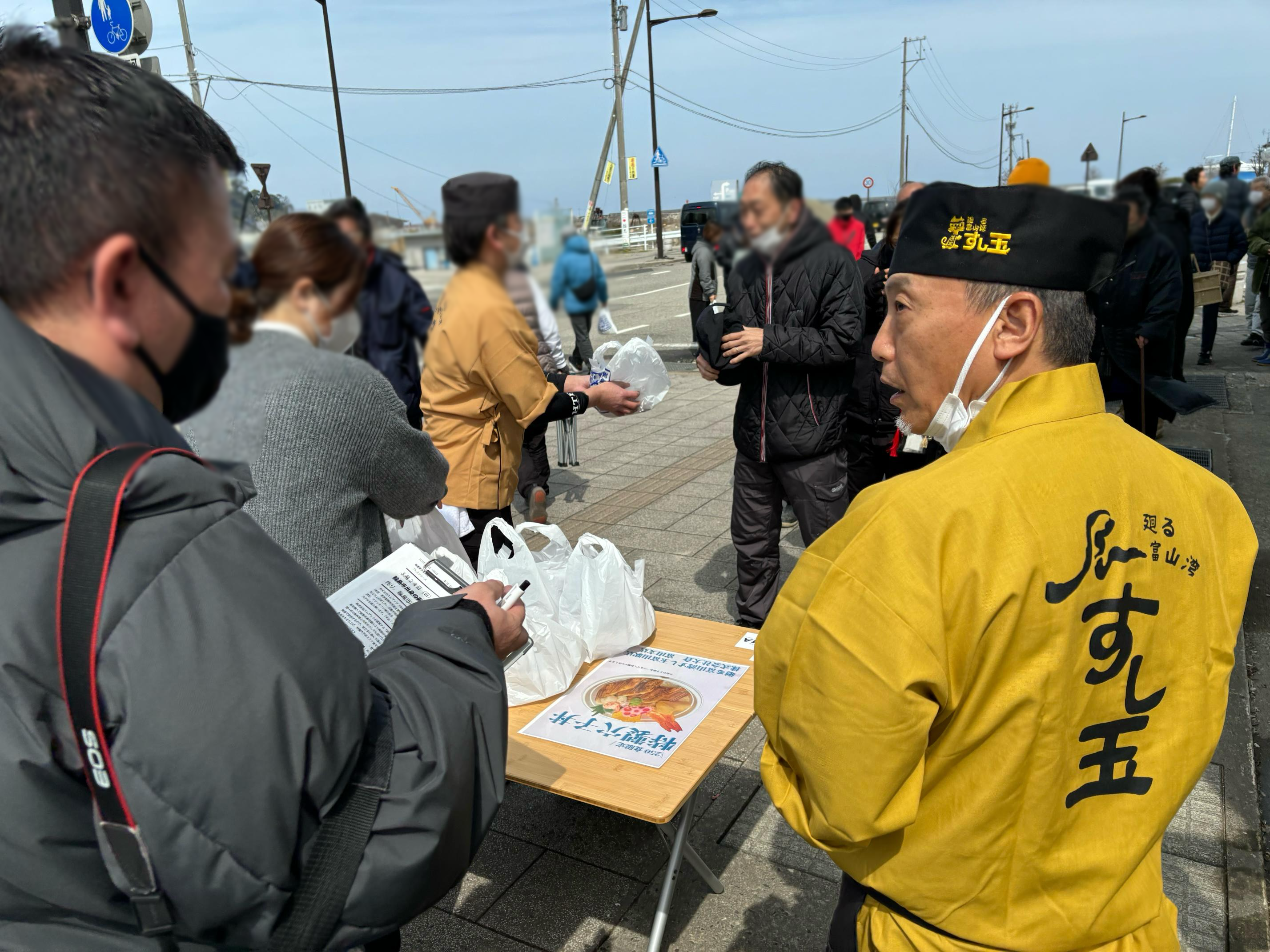 振る舞い中も各社の取材を受ける㈱エムザック　寺西代表